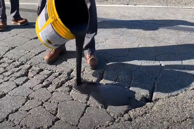 Asphalt Paving worker sealcoating the crack